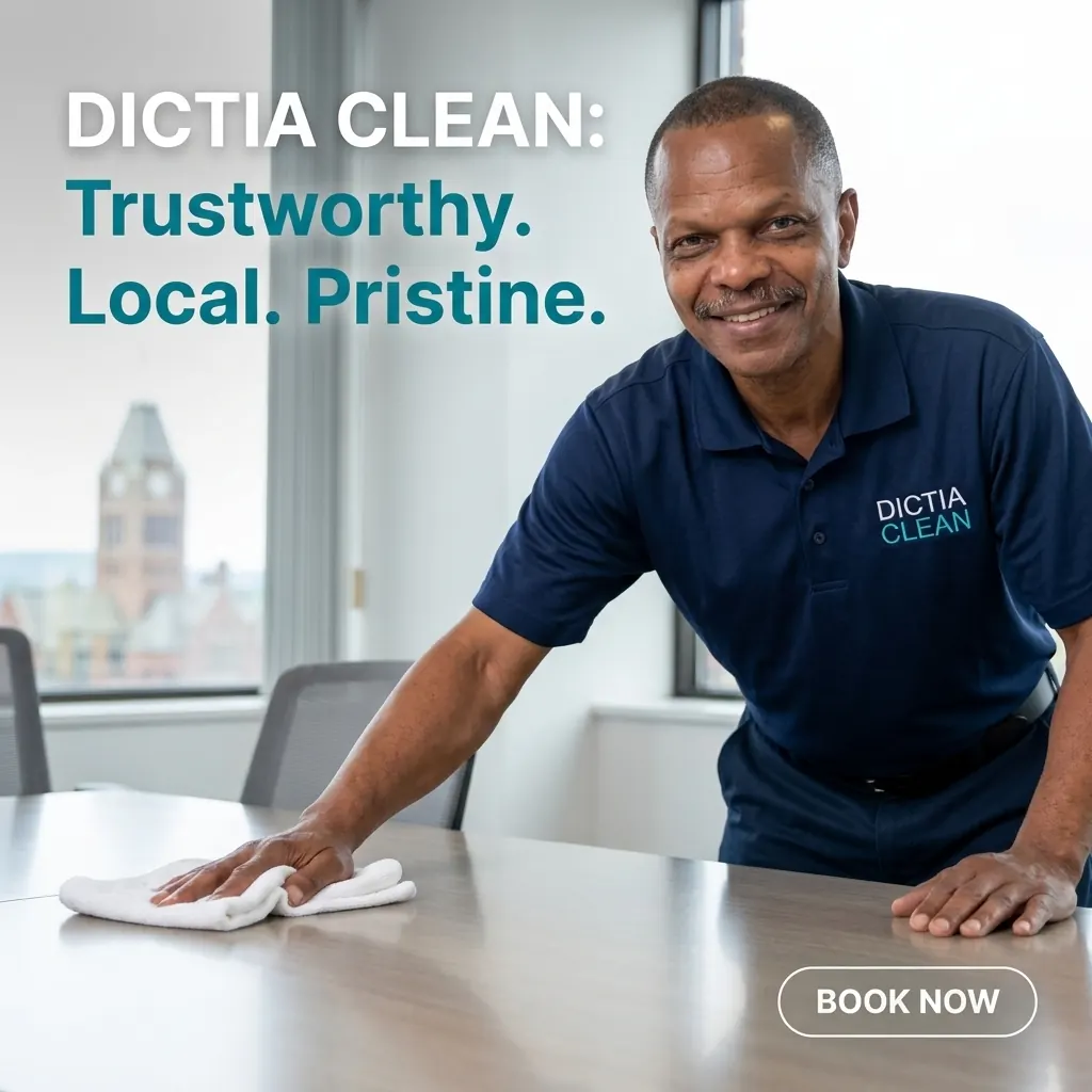A Dictia Clean team member in a navy polo wiping down a boardroom table in a Syracuse office